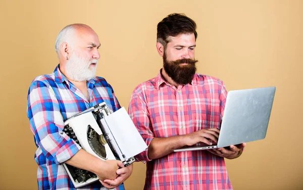 master service. youth vs old age. business approach. father and son. family generation. retro typewriter vs laptop. New technology. technology battle. Modern life. two bearded men. Vintage typewriter