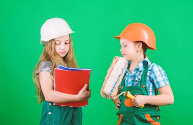 İşçi bayramı. 1 mayıs. Foreman müfettişi. Onarım. okul projesi. küçük kızlar atölyede birlikte tamir. Tablet ve rulo ile kask küçük çocuklar. İşçi Bayramı konsepti. Çocuklar için çalışma günü