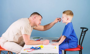 Erkek doktor, küçük çocuk hastayı muayene etmek için masaya oturur. Sağlık hizmetleri. Çocuk doktoru konsepti. Çocuk bakımı. Çocuğun sağlığını kontrol ederken dikkatli ol. Tıbbi muayene. Tıbbi hizmet