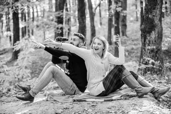 Concept d'expédition. couple amoureux se détendre dans la forêt d'automne avec du thé ou du café. Pique-nique familial. camping et randonnée. surprise fille boire vin chaud. homme barbu montre choquée avec des jumelles. Printemps — Photo