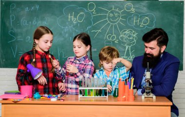 Formül neredeyse tamamlandı. laboratuvarda mikroskopla bilim deneyleri yapıyor. Okula geri dön. bilim okuyan çocuk bilim adamı. mutlu çocuklar. Okul laboratuvarında kimya öğrenen küçük çocuklar