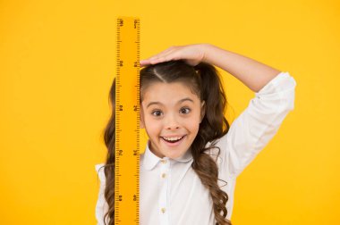 Hala büyüyorum. Uzun boylu çocuk. Çocuk okulu üniforması cetveli tutar. Büyük cetveli olan tatlı bir öğrenci. Geometri dersi. Eğitim ve okul konsepti. Boyut ve boyut. Okul öğrencisi geometri okuyor.