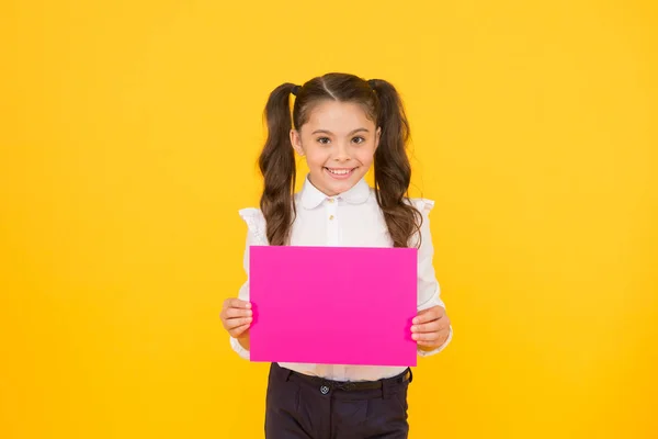 Próximo evento. Olha para isto. Menina escola uniforme segurar cartaz. Estudante segurar poster espaço de cópia. Promoção de informação de notícias. As mudanças estão a chegar. De volta ao conceito de escola. Estudante aluno mostrar cartaz — Fotografia de Stock