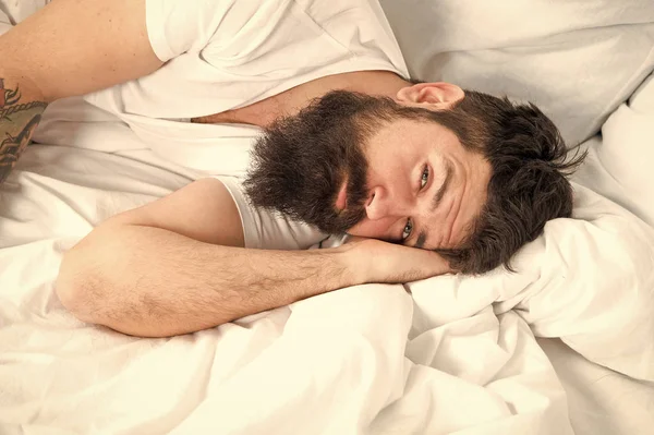 Sleep disorders concept. What a long night. Man bearded hipster having problem with sleep. Guy lying in bed try to relax and fall asleep. Relaxation techniques. Violations of sleep and wakefulness