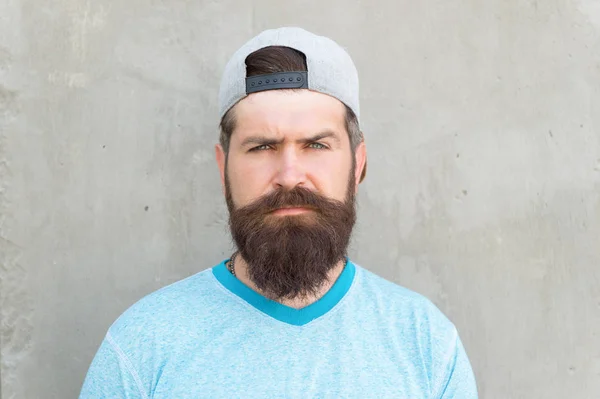 Baard en snor. Een man met baard op een grijze muur. Serieuze bebaarde hipster in casual zomerstijl. Blanke man draagt lange snor en baard haar op bebaarde gezicht — Stockfoto