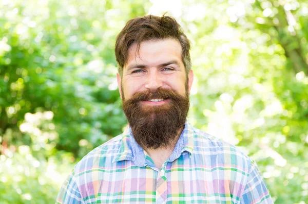 Sourire augmente le bonheur. Homme barbu au visage souriant et joyeux sur un paysage naturel. Un hipster souriant portant une moustache élégante et des poils de barbe le jour de l'été. Je suis toujours souriant et heureux — Photo