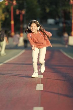 Çalma listesi active gün için. Kulaklık ile sevimli bir kız. Küçük çocuk aktivite keyfini çıkarın. Çocuk Parkı müzik dinleme çalıştıran yürüme. Müzik bana enerji ile doldurur. En sevdiğim müzik kulaklık ile yürüyüş zevk