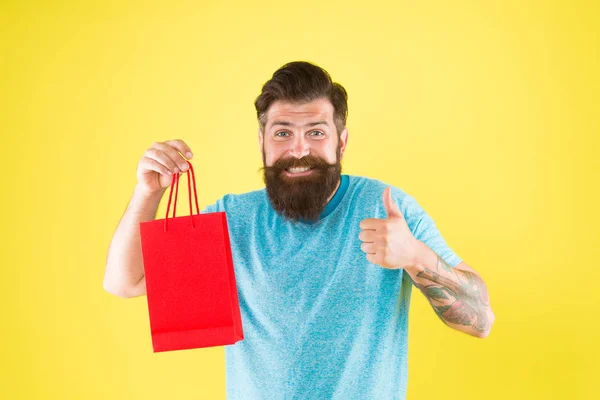 Bearded man smiling with purchase. Impulse purchase. Shopping concept. Shop store mall boutique. Buy product. Aspects can influence customer decision making behavior. Happy hipster hold paper bag — Stock Photo, Image