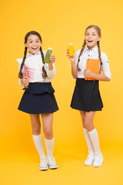 Smoothie detoxikační. Moje hladové. Zdravá výživa. Školačky drží na žlutém pozadí láhev s šťávou. Při školním čase uhasit žízeň. Žízeň a dehydratace. Zdravé občerstvení — Stock fotografie