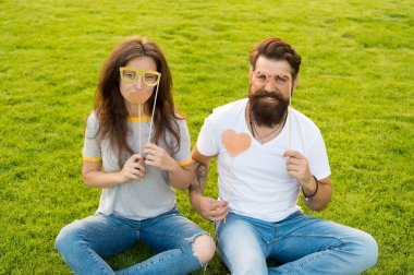 Çift aşık neşeli gençlik standı sahne. Duygusal insanlar. Çift randevuları. Tasasız çift eğlenceli yeşil çim sahip. Adam sakallı hipster ve güzel kadın neşeli yüzleri. Gençlik günü. Yaz eğlencesi