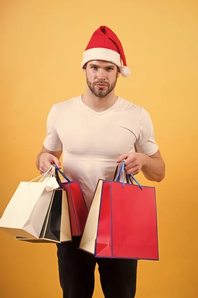 Online julhandeln. Gott Nytt År. På morgonen innan Xmas. lycklig santa man på gul vägg. leverans julgåva. mannen i santa hatt hålla julklapp. God Jul. Att välja nuvarande — Stockfoto