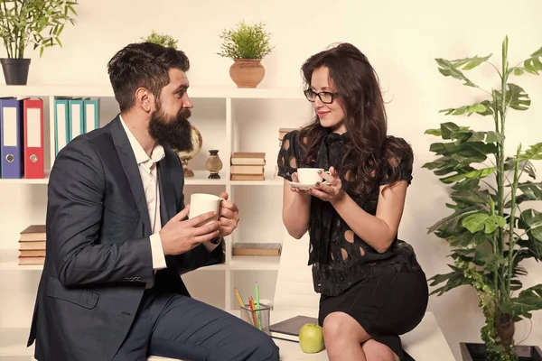 Man en vrouw aangenaam gesprek tijdens de koffiepauze. Praten over kantoorgeruchten. Vraag om aanbevelingen. Koffie tijd om te ontspannen. Een paar collega 's ontspannen met koffie. Koffiepauze met collega — Stockfoto