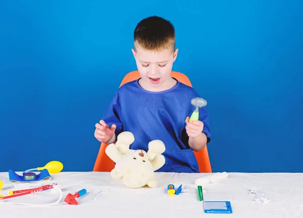 Medical procedures for teddy bear. Boy cute child future doctor career. Hospital worker. Health care. Kid little doctor busy sit table with medical tools. Medical examination. Medicine concept