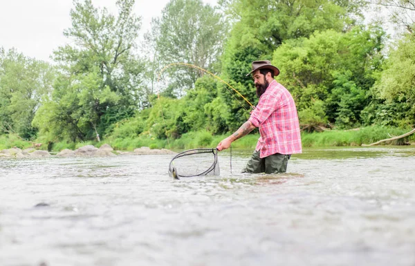 Forza Fish. pescatore con canna da pesca. hobby e attività sportive. Pothunter. uomo maturo pesca a mosca. uomo cattura il pesce. weekend estivo. Pesca d'altura. pescatore barbuto in acqua — Foto Stock