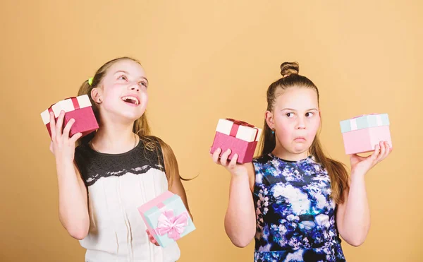 A los niños les encantan los regalos. Compras y vacaciones. Las hermanas disfrutan los regalos. Los niños sostienen cajas de regalo de fondo beige. Feliz día. Niños niñas encantado regalo. Niñas adorable celebrar cumpleaños — Foto de Stock