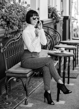 Keyifli zaman ve boş zaman. Rahatlayın ve kahve molası verin. Seni duyduğuma sevindim. Kadın çekici zarif esmer eğlence kafe teras arka plan harcamak. Boş zaman konsepti. Akıllı telefon ile kız moda bayan