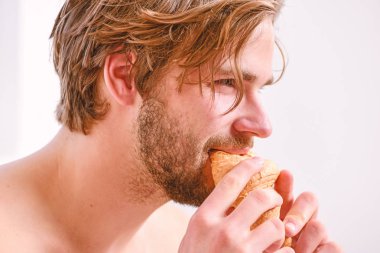 Yatak odası ya da otel odasında yatıyordu yatak süre tutar kruvasan ve kahve sahip adam. Rahatlama ve dinlenme. Uyuyan adam tarafından yatak odasında cep telefonu uyandı. Yatakta kahvaltı.