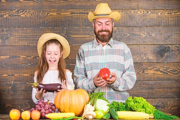 Farm market with fall harvest. Family farm festival concept. Family father farmer gardener with daughter near harvest vegetables. Man bearded rustic farmer with kid. Countryside family lifestyle