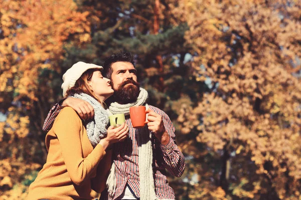 Couple in love sits in park holding cups of tea — Stock Photo, Image