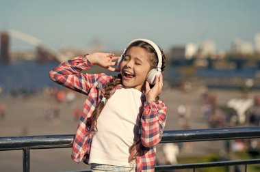 Müzik ailesi aboneliğini al. Milyonlarca şarkıya erişim. Her yerde müziğin tadını çıkar. Dinlemeyi hak eden en iyi müzik uygulamaları. Kız çocuk açık havada modern kulaklıklarla müzik dinler. Bedavaya dinle.