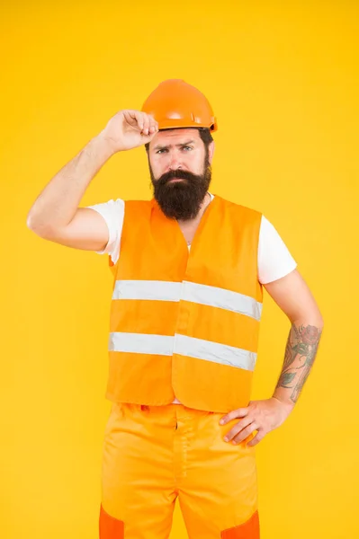 Labor day. Safety apparel for construction industry. Bearded brutal hipster safety engineer. Engineering career concept. Architect builder engineer. Man engineer protective uniform orange background