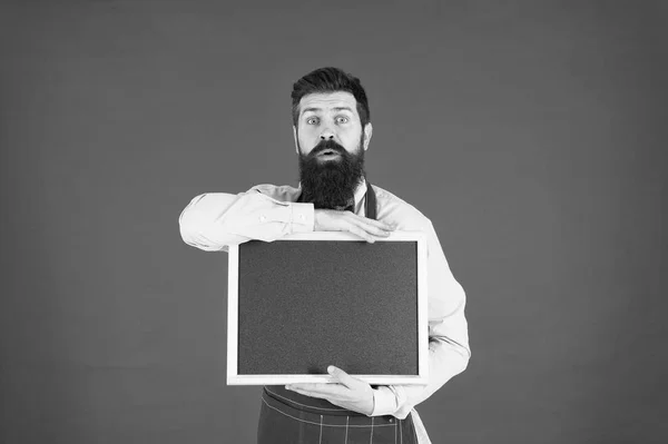 Recipe. great cuisine. cooking by recipe. menu board. bearded hipster cook in apron. welcome. Restaurant or cafe advertising. surprised man chef with blank blackboard, copy space. best recipes here
