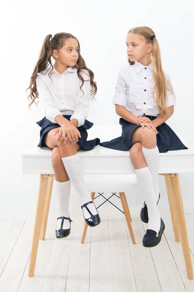 Porque estás triste? Estudantes arrumado penteado relaxante ter descanso. Uniforme escolar. Clube da escola. Pequenas alunas colegas de turma crianças amigáveis. As alunas amigas sentam-se na secretária. Melhores amigos relaxante — Fotografia de Stock