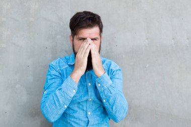 Burun akıntısı. Hapşırma yüzü ile Adam sakallı hipster kapalı gözleri beton duvar arka plan kadar kapatın. Acımasız hipster hapşırma. Alerji ilaçları alın. Hapşırmayı bırakamıyorum. Soğuk algınlığı tıbbi tedavileri