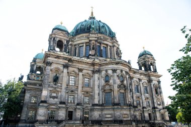 Mimari miras. Kubbeli kilise veya katedral. Çatının üstündeki kule haçı. Eski şehir mimarisi kavramı. Büyük kubbebakır patina çatılı katedral. Muhteşem katedral cephesi