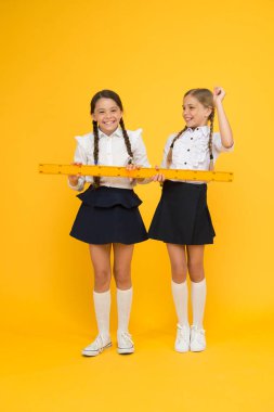 Geometri favori konu. kök disiplinler. Okula geri dön. Matematik ve geometri. Üniformalı çocuklar. okul arkadaşlığı. mutlu küçük kızlar matematik çalışır. öğrenciler sarı cetvel kullanın