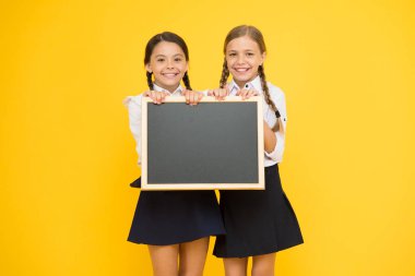 Bilgin olsun diye söylüyorum. Küçük çocuklar sarı arka plan hakkında bilgi almak için boş tahtayı tutuyorlar. Okul bilgisi için düzgün tahtaları olan küçük kızlar. Sizin için bilgi, kopyalama alanı