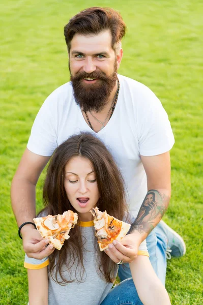 I want them all. summer picnic on green grass. Diet. happy couple eating pizza. Healthy food. fast food. bearded man hipster and pretty woman eat pizza. hunger. family weekend. couple in love dating — Stock Photo, Image