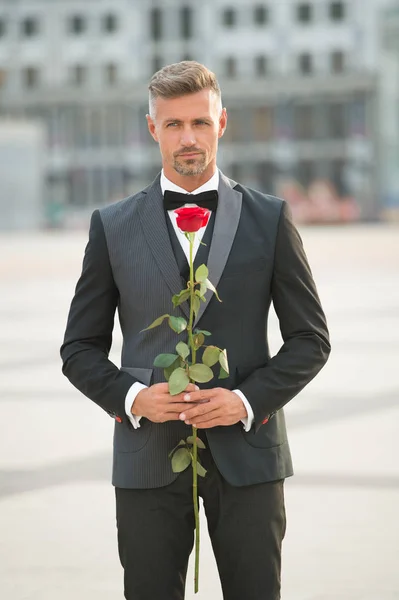 Romantic gentleman. Man mature confident macho with romantic gift. Handsome guy rose flower romantic date. Ability to surprise. Valentines day and anniversary. Dating services. How to be romantic