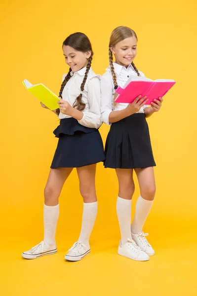 Reading story. childrens literature. dictionary notebook. Get information. kids learning grammar. back to school. cheerful classmates with workbook. little girls in school uniform. A Novel Idea — Stock Photo, Image