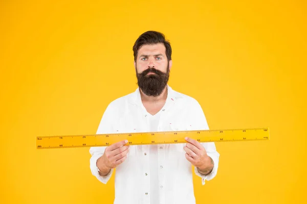 O tamanho realmente importa. Homem barbudo hipster segurando governante. Meça o comprimento. Tamanho alto e comprimento. Tamanho grande. Medida e controle. Teorema da geometria. Tamanho real. Professora. Pequeno pequeno grande grande — Fotografia de Stock