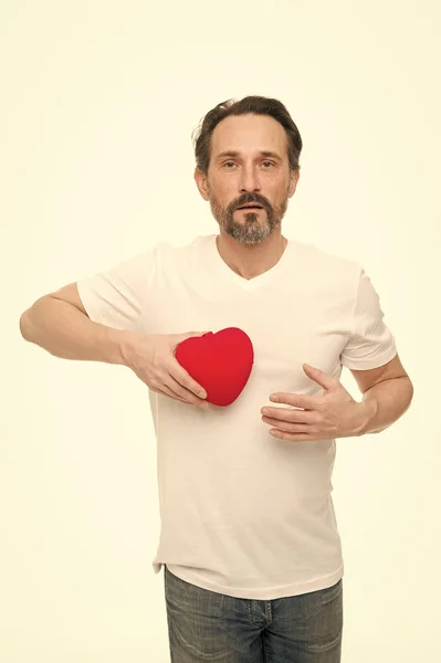Heart attribute of valentine. Heart gift present. Greeting from sincere heart. Man bearded hipster hold heart. Romantic guy fall in love. Celebrate valentines day. Love and romantic feelings concept