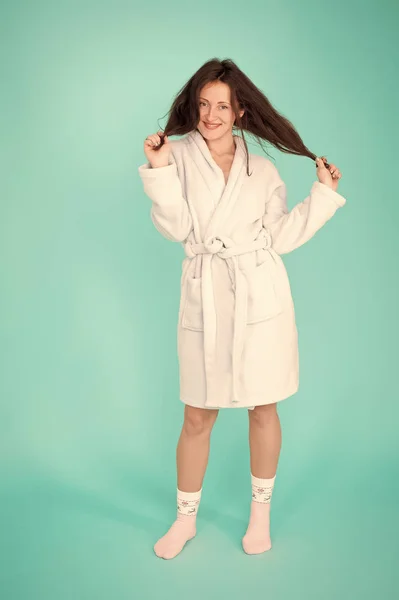 Girl no makeup face long hair wear bathrobe turquoise background. Ready for spa procedures. Woman relaxed after massage session or spa. Beauty salon. Spa and skin care. Spa and wellness concept