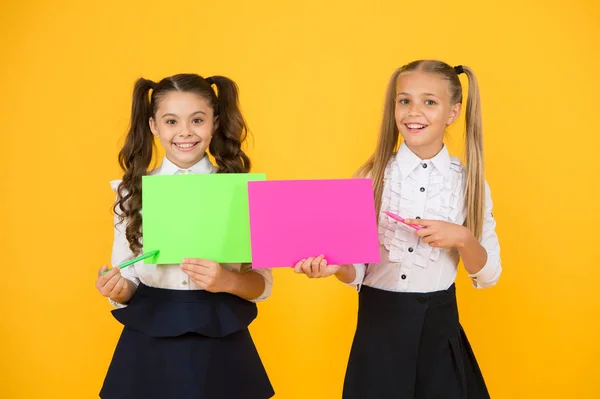 L'uniforme de l'école des filles tient affiche. Concept de communication visuelle. L'amitié scolaire. Les écolières montrent l'affiche. Présentation affiche copie espace. Enfants présentant leurs propres projets. Expliquer le point principal — Photo