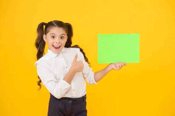 Changements à venir. Prochain événement. Regarde là. L'uniforme de l'école des filles tient affiche. Retour à l'école. Affiche d'écolière. Écolière tenir affiche copie espace. Promotion de l'information — Photo