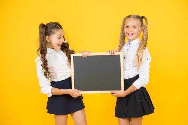 Heureux d'informer. Des écolières vous informent. Les écolières ont un espace de copie vierge. L'uniforme des filles tient le tableau noir. Retour à l'école. Prochains événements à l'école. Communication visuelle — Photo