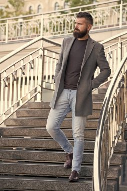 Merdivenlerden aşağı. Havalı günlük kıyafet bahar sezonu. Erkek giyim ve erkek moda konsepti. Erkek sakallı hippi modaya uygun bir ceket ya da ceket. Rahat bir kıyafet. Moda mankeni hippi.