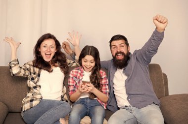 Küçük kız kullanma smartphone ile çocuk anne. Dostu aile birlikte eğleniyor. Anne baba ve meşgul kızı kanepede rahatlatıcı. Aile eğlence. Ebeveyn Danışma belgesi. Aile birlikte hafta sonu geçirmek