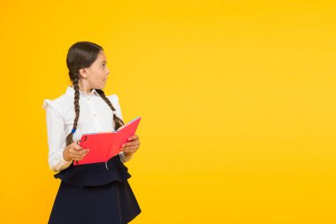 Dil eğitimi. Evde çalış. Ders kitabı ile sevimli çocuk çalışması. Okul çalışmaları için okuma becerilerini pratik edin ve geliştirin. Okul konseptine geri dönelim. Kız kitap tutun. Sarı arka planda okul kız