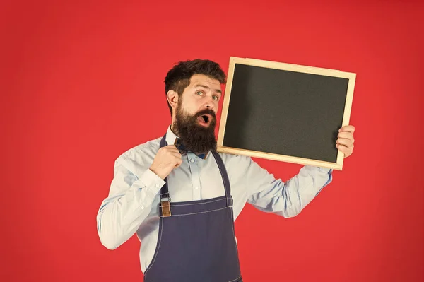 Exklusiver Cocktail. Mann bärtigen Barkeeper oder Koch in Schürze halten leere Kreidetafel. Preislisten-Konzept. Hipster-Barkeeper zeigen Tafel Kopierraum. Hipster-Restaurantpersonal. Hipster informieren — Stockfoto