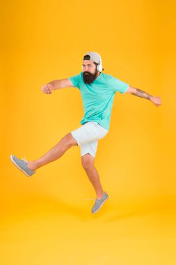 Sakallı adam müzikten hoşlanır. Müzik hayranı. Adam hareket halinde müzik kablosuz kulaklık lar dinleyin. Aceleci hareket. Hipster dans atlama kulaklık gadget. İlham verici bir şarkı. Müzik kütüphanesi. Ritim enerjisi