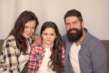 Aile hafta sonunu birlikte geçirir. Dost canlısı aile fotoğraf aile albümü için poz kanepede oturup. Anne baba ve kızı kanepede rahatlatıcı gülümsüyor. Aile bağları kavramı. Tek çocuklu tipik aile