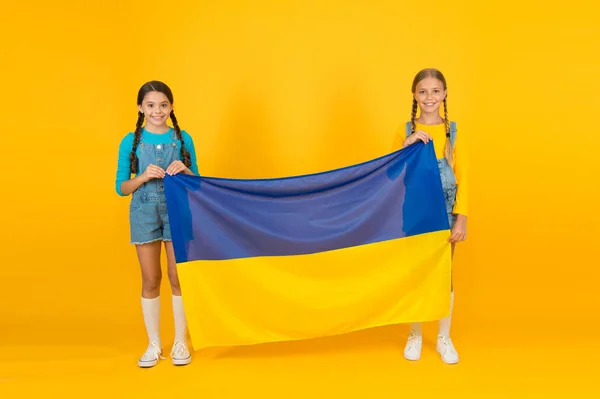 Der Patriotismus respektiert und liebt das Vaterland. Nationale Identitätskonzeption. Ukrainische Kinder. Mädchen mit blauer und gelber Fahne. Patriotische Erziehung. Glücklicher Unabhängigkeitstag. Kinder halten ukrainische Fahne hoch — Stockfoto