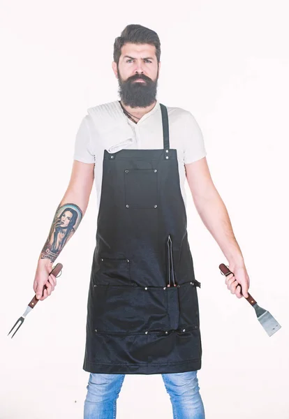Yemek pişirmek ve servis yapmak için hazır. Elinde çatal ve spatula olan sakallı adam. Barbekü pişirme için mutfak araçları. Paslanmaz çelik mutfak gereçleri tutan hipster. Pişirme aracı seti kullanarak ızgara pişirmek — Stok fotoğraf