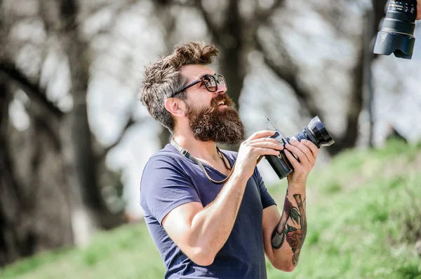 Dame una sonrisa. hombre hipster en gafas de sol de verano. foto de la naturaleza. reportero o periodista. Hipster maduro con barba. Hombre barbudo. equipos fotográficos retro. brutal fotógrafo con cámara —  Fotos de Stock