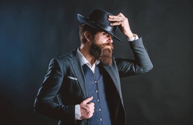 Şapkalı adam. Vintage moda. Karanlık arka planda adam iyi bakımlı sakallı beyefendi. Erkek moda ve Menswear. Retro moda şapka. Resmi takım elbise klasik tarzı kıyafet. Zarif ve şık hipster
